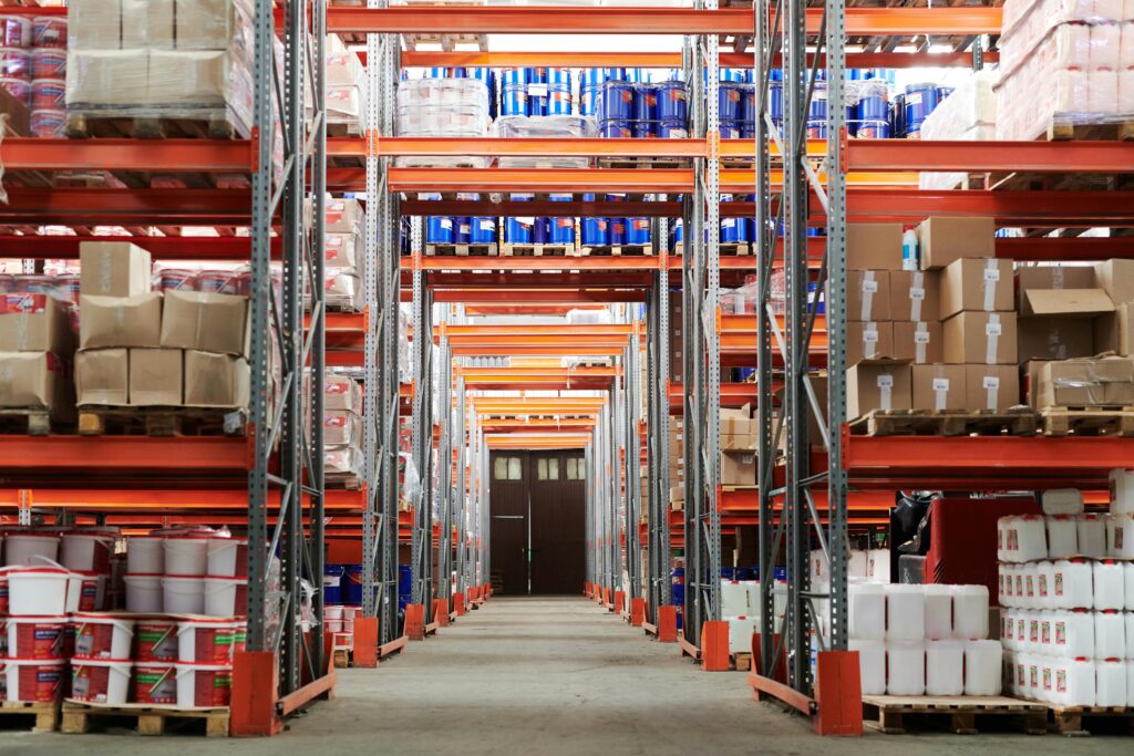 pexels-photo-4483610-4483610-1 Wide angle view of a warehouse with stocked shelves and boxes.